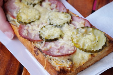 baked in the oven sandwich with cheese, sausage and cucumbers. crispy bun and juicy filling, street food, fast food, snack on the go. take away