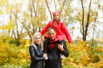 Fototapeta premium Happy family walking on the rural dirt road. Little girl sitting on dad's shoulder