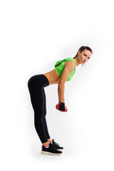 Obraz premium Sporty girl doing exercises with dumbbells at biceps on white background.