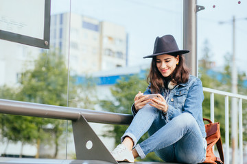 Lonely girl sits on the steel bench waiting for someone