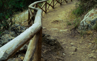 earthen stone walkway eco walk fence wooden thick smooth logs turn road background journey rest