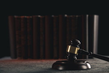 Law concept - Open law book with a wooden judges gavel on table in a courtroom or law enforcement...