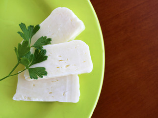 Slice of cheese in the plate, whole fat cheese