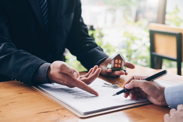 real estate agent holding house key to his client after signing contract,concept for real estate,...