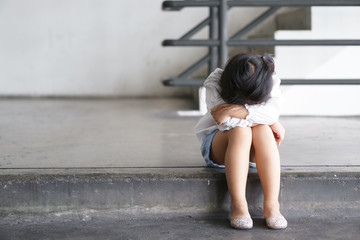 Asian child touchy or kid girl sleeping and angry cry with sad or have problems and bend down the head lonely to wait for the parents on city street at nursery or kindergarten and pre school