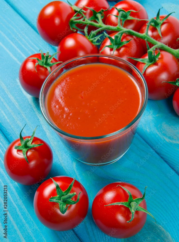 Wall mural Fresh tomato juice as a source of vitamins. Wooden background.