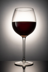 Red wine in a glass goblet on a table on a white background