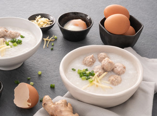 Rice congee with minced pork in white bowl. Bowl of rice porridge with soft boiled egg. Asian breakfast