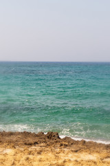 vertical photo azure bright sea Mediterranean wild stone desert beach weathered vacation deserted beach