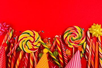 Colorful candies on a red  background. Lollipop. Top view. Copy space.