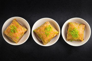 Pistachio baklava on a black plate. Dessert.