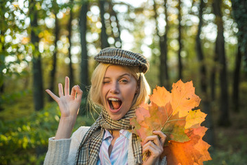 Happy autumn girl wink, Ok. Autumn outdoor atmospheric moments and dream. Autumn and leaf fall...