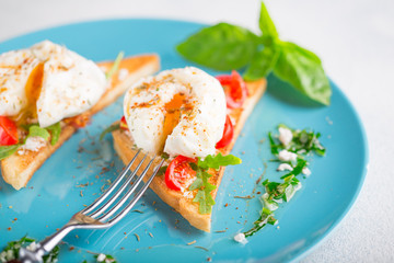 Poached eggs and toasted toast on a blue plate