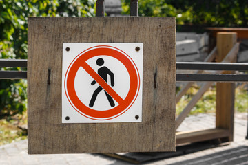 road sign prohibiting the movement of pedestrians on an old wooden board near the fence. the sign of the pedestrian passage is prohibited near scene of the accident. No access for pedestrians