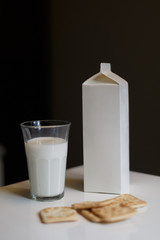 Carton box and glass of milk on table in kitchen