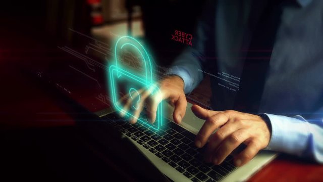 Cyber attack, hacking, phishing, spyware, crime and theft concept. Hacker typing on laptop open padlock protection and access to data. Man and skull hologram screen over keyboard. Hand camera shake.