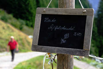 Hinweis auf einer Schiefertafel: Heute Apfelstrudel, im Hintergrund ein Mann im roten Shirt, der...