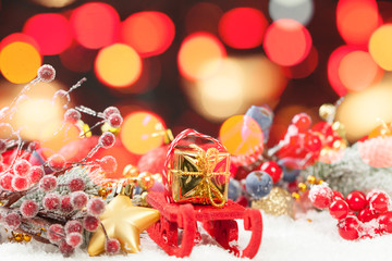 Christmas bokeh background with Santa sleigh, gold gift, red holly berries and colorful Xmas...
