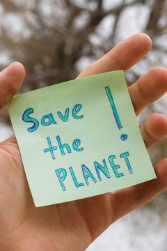 Save the Planet! - handwritten lettering quote on paper sticker in hand. Earth protection, Planet and Environmental Protection concept, vertical image.