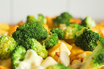Baked potatoes with cheese, broccoli, mushrooms, turmeric and other spices from the oven close-up.