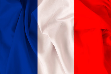 beautiful national flag of France on soft silk with soft folds, close-up, copy space