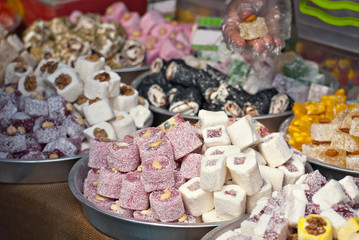Turkish national sweets are sold at the fair. Multi-colored Asian desserts stacked on the table. Rahat lokum in bulk is sold at the festival.