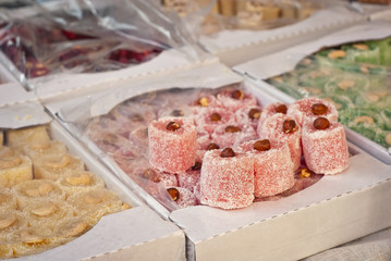 Turkish national sweets are sold at the fair. Multi-colored Asian desserts stacked on the table. Rahat lokum in bulk is sold at the festival.