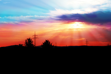 natural landscape with black silhouette of trees and a beautiful romantic sunset with rays