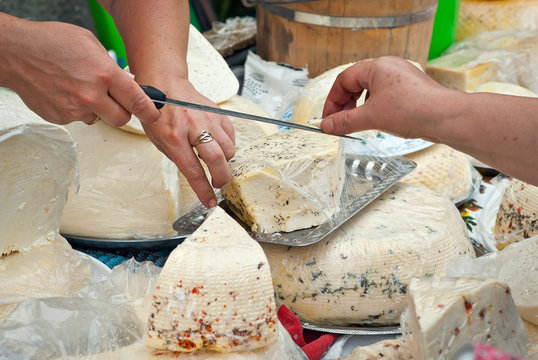 Different types of cheese on the table. Many cheese is sold at an agricultural fair. Natural home product.