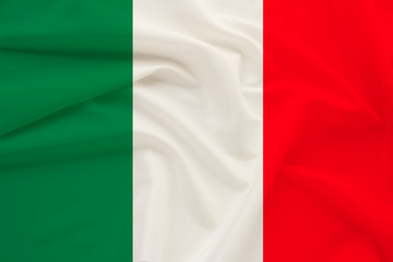 The national flag of the country of Italy on gentle silk with wind folds, travel concept, immigration, politics, copy space, close-up