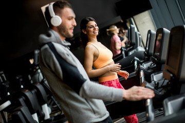 Fototapeta na wymiar Young people using threadmill in modern gym