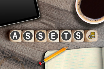 Cubes and dice with term Assets on wooden background
