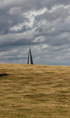 Church tower behind a field