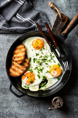 fried eggs in a cast iron pan top view