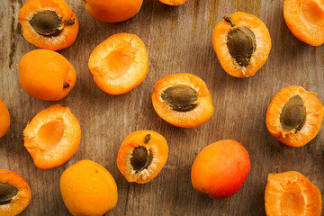 selective focus, halves of apricots with seeds from whole fruits on a dark textured wooden Board