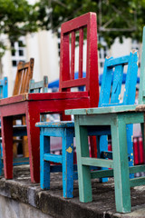 lineup of colorful wooden chairs of various sizes