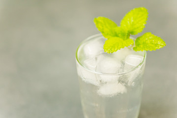 Delicious cold drink. Glass with ice cubes. Fresh icy cold cool freshening liquid. Beautiful background.