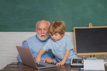 Portrait of creative young smiling Pupil. Daddy and his little son. Generation. Family generation and relations concept. Grandfather and grandson in school. Grandfather.