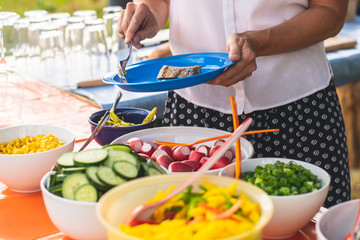 grilling in the garden, a person holds a plate of food in his hand
