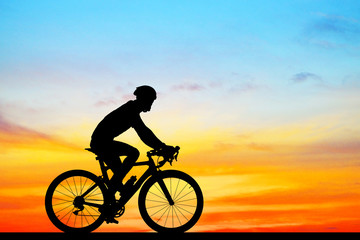 Obraz na płótnie Canvas Silhouette Cycling on blurry sunrise sky background.