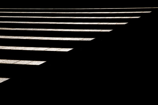 mitad de la foto en lineas blancas cortadas en diagonal resaltando en fondo negro  que ocupa la otra mitad 