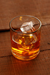 Chilled Whisky Glass with Ice Cubes on Wooden Table