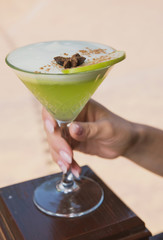 cocktail with cream, cinnamon, Apple slice in a beautiful glass on the background of nature