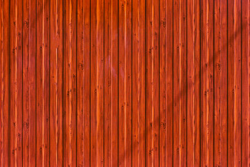 Fence made of wooden vertical bars.