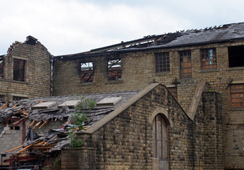Fototapeta premium an old abandoned large industrial building with burned out broken windows and collapsing roof
