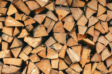 Wall of dry chopped firewood logs in a pile. The concept of rural life, summer harvesting for the winter, retro, wood, natural materials. Place for text, minimalism.