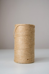 Fototapeta na wymiar Natural jute twine roll on light background. Material for packaging.