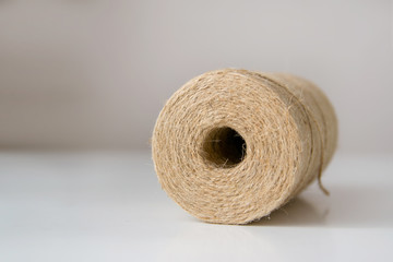 Natural jute twine roll on light background. Material for packaging.