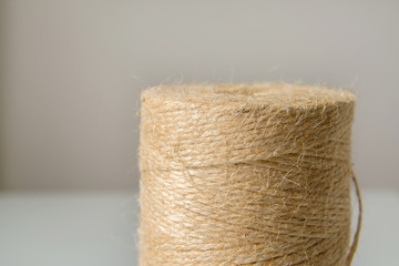 Natural jute twine roll on white background. Material for handmade close-up.