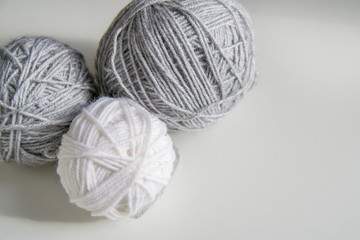 three ball of wool yarn for knitting, gray ball of yarn, white ball of yarn on white background